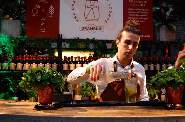 Man with Drambuie from the drinks cabinet making cocktails