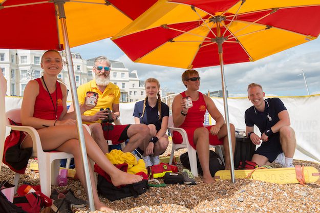 Group of lifeguards on the beach with Haagen-Dazs. brand sampling