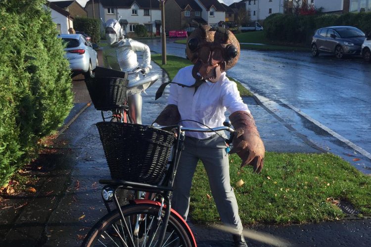 Man dressed as movie monster on bike