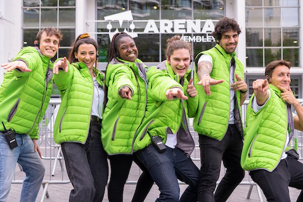 Work colleagues all dressed in green puffers at SSE Arena event being friendly.