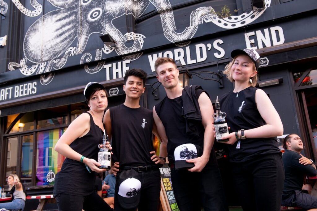 Work colleagues all dressed in black at Kraken rum event being friendly.